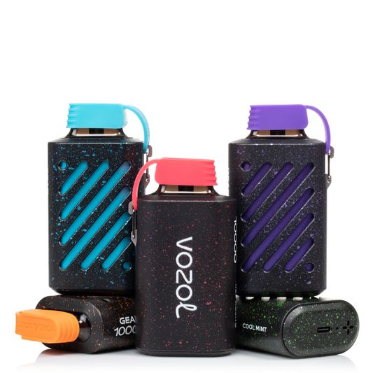 Three VOZOL vaping devices with colorful lids on a white background